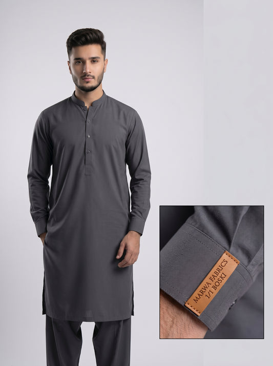 Man wearing a gray kurta with a close-up of the brand label on a light gray background