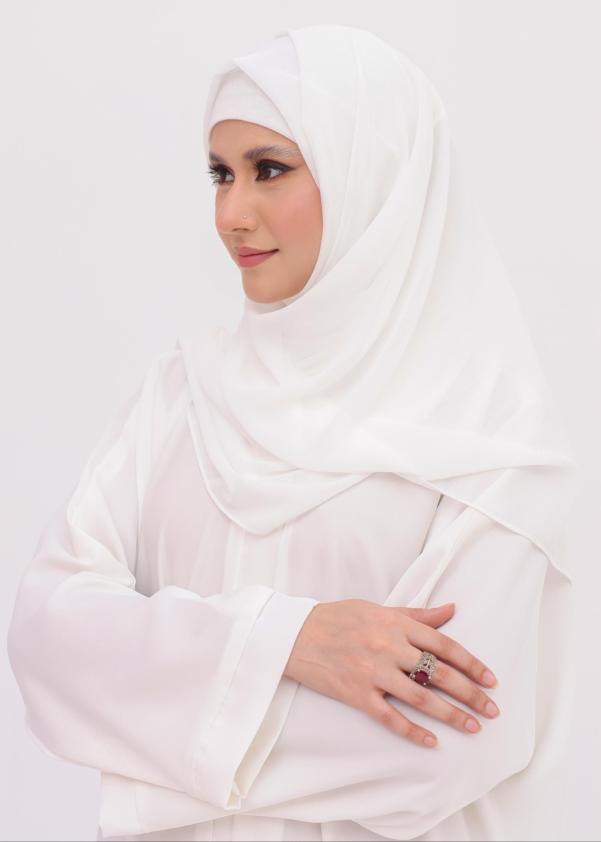 Woman wearing a white hijab white nida front open abaya