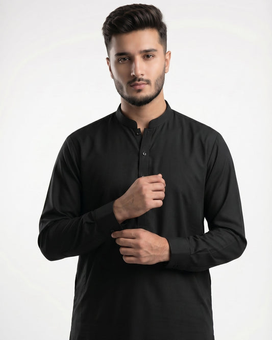 Man wearing a black kurta against a white background