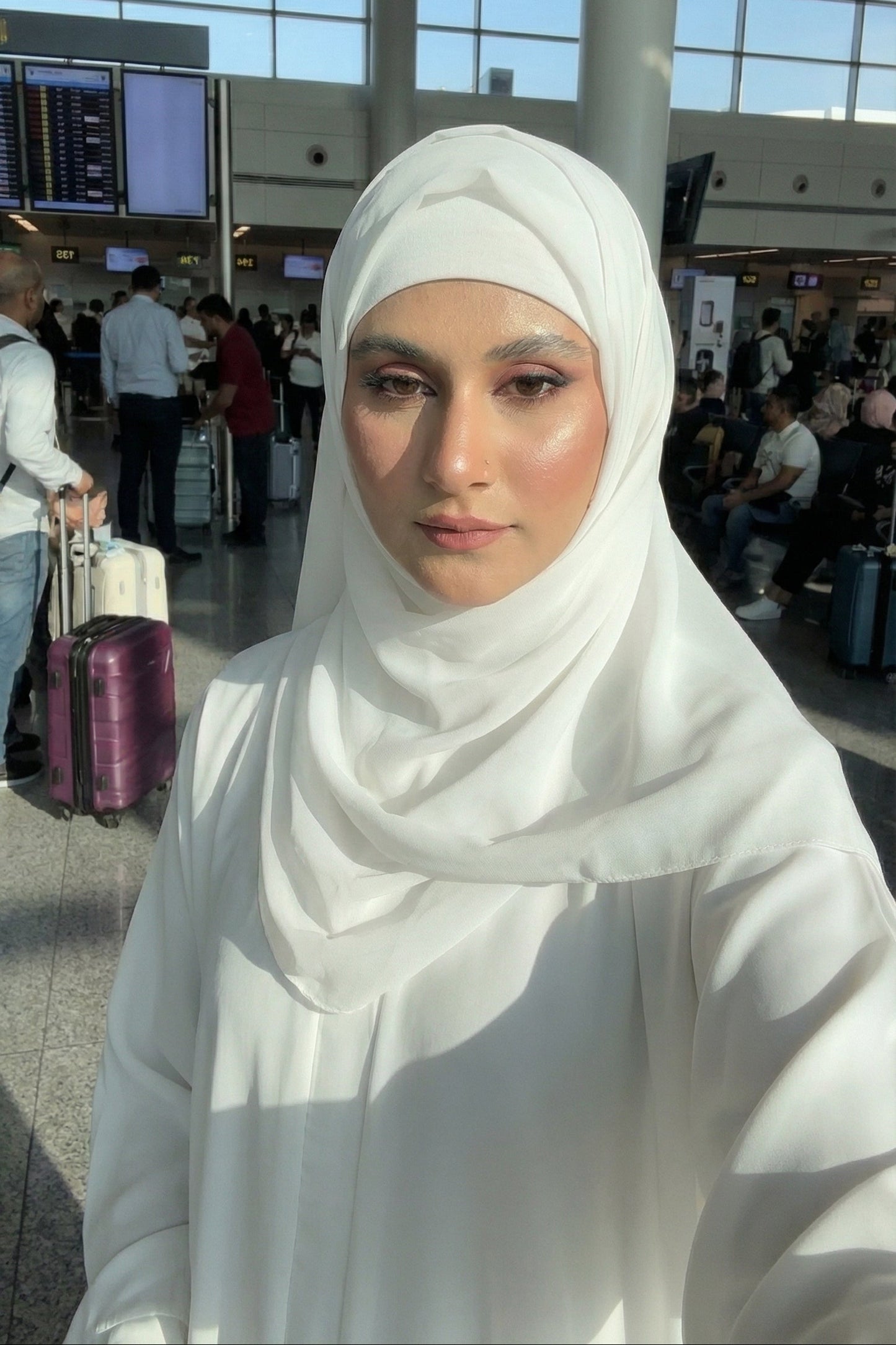 Woman wearing a white hijab in an airport setting